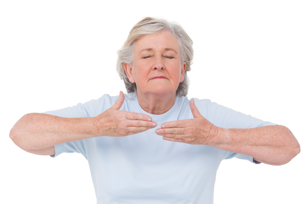 Senior Woman Doing Yoga Exercise On White Background